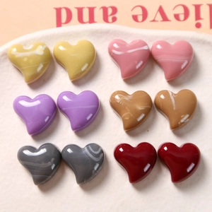 Flat lay of heart-shaped resin charms with marble textures for DIY jewelry making