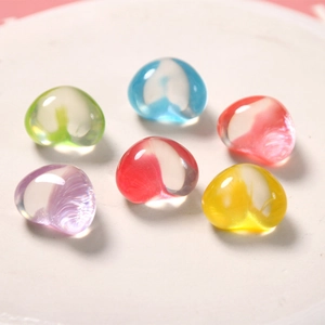 Dettaglio macro di sei ciondoli a cuore in resina trasparente con glitter in vari colori
