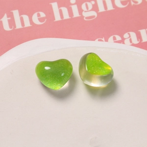 Dettaglio di ciondoli a cuore in resina glitterata verde per orecchini e gioielli fai da te