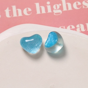 Dettaglio macro di cuori in resina blu con glitter su un piatto in ceramica bianca