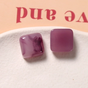 Primer plano de dijes cuadrados de resina para pendientes con textura de mármol púrpura