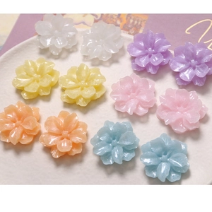 Macro detail of glittery resin gardenia charms in pastel macaron colors for DIY jewelry
