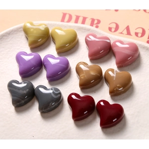 Macro detail of marble pattern heart resin charms for DIY earring and hair clip making