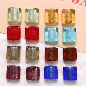 Makroaufnahme von 16 bunten quadratischen Glasperlen mit Metallfolie für DIY-Schmuck
