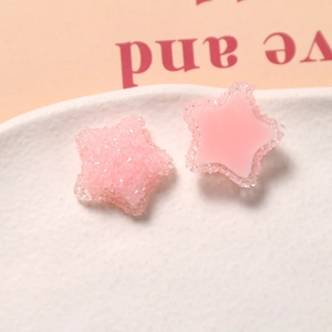 Makroaufnahme von rosa Harz-Stern-Anhängern mit feiner Zuckerbeschichtung für DIY-Schmuck