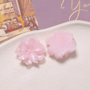 Macro shot of pink resin gardenia flower charms showing front and flat back details