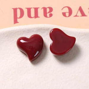 Close-up of deep red glossy heart-shaped resin charms for DIY jewelry and hair accessories