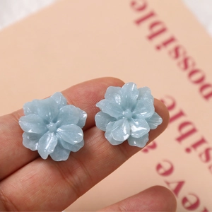 Macro shot of glittery light blue resin gardenia flowers for DIY jewelry making