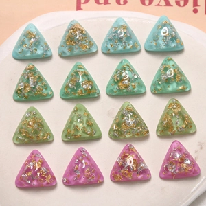 Détail de breloques en résine triangulaire avec feuille d'or pour bijoux artisanaux