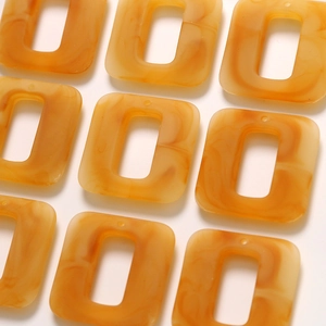 Flat lay of caramel marble resin rectangle frames with hollow center for DIY earrings