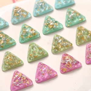 Vue macro de breloques en résine triangulaires avec feuille d'or pour bijoux DIY