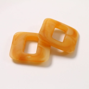 Close-up of caramel square resin beads with marble texture for DIY jewelry making