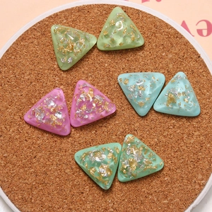 Vue macro de breloques triangulaires en résine avec feuilles d'or pour bijoux DIY