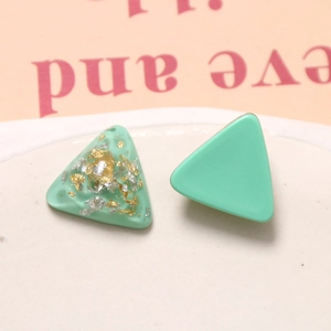 Macro de boucles d'oreilles triangulaires vert menthe avec détails en feuilles d'or