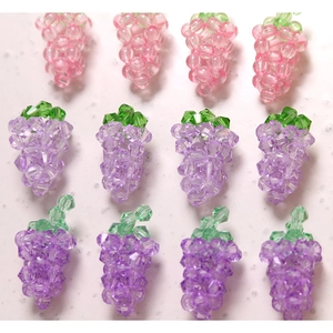 Macro detail of faceted crystal grape beads with green leaf accents for DIY jewelry craft