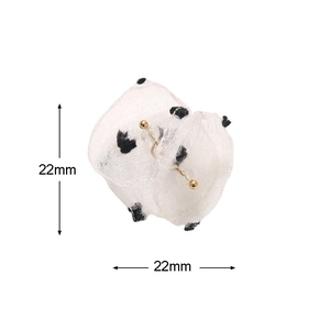 Detail of 22mm black polka dot white gauze flower accessory with golden bead center