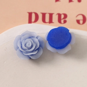 Macro view of blue resin rose flower charms showing matte petal texture and flat back