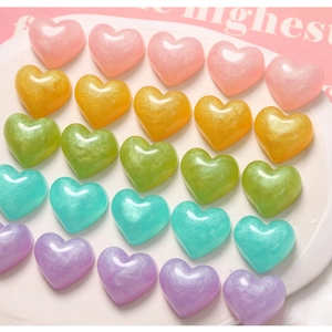 Close-up of 25 glitter resin hearts in pastel colors for DIY jewelry and phone case decor