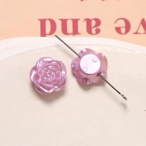 Macro view of purple pearlescent rose beads showing fine relief and perforation detail