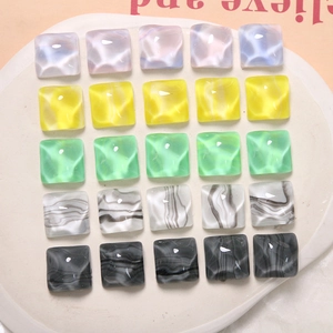 Macro detail of square resin charms with marble water ripple patterns in multiple colors