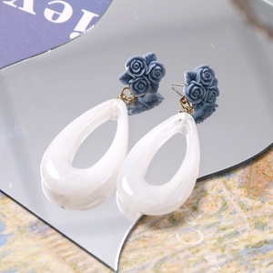 Detail of blue resin rose earrings with hollow white teardrop pendant and vintage style