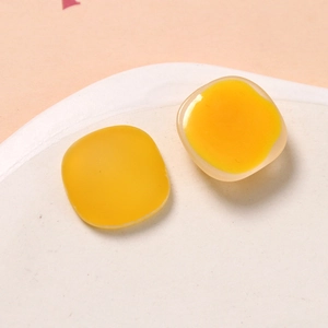 Macro shot of yellow square resin craft accessories with matte and glossy jelly texture