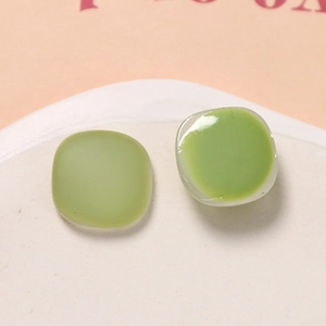 Close-up of Morandi green square resin charms on a ceramic tray for DIY jewelry making
