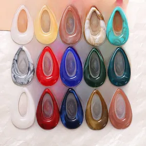 Macro shot of 15 colorful resin teardrop charms with artistic marble and ink textures