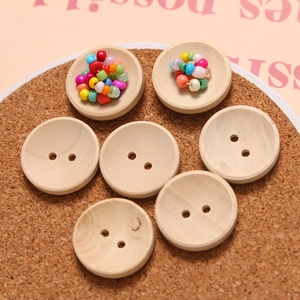 Macro view of two-hole wooden buttons with natural wood grain on a cork background
