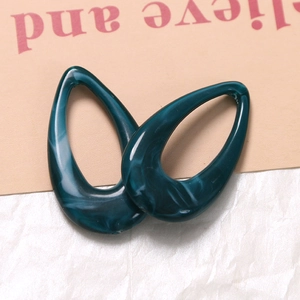 Detailed macro view of hollow teardrop resin pendants with teal marble texture effects