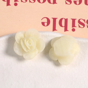 Vista macro de dos rosas de resina crema para joyería DIY y accesorios para el cabello