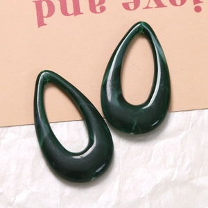 Detail of drop-shaped resin pendant with green malachite texture for jewelry making