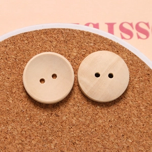 Macro shot of two-hole concave wooden buttons showing natural grain texture on cork