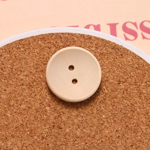 Macro shot of a round concave two-hole wooden button for sewing and DIY crafts