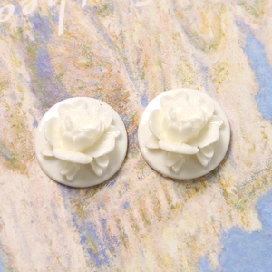 Detailed macro view of two creamy white resin rose petal charms for DIY craft making