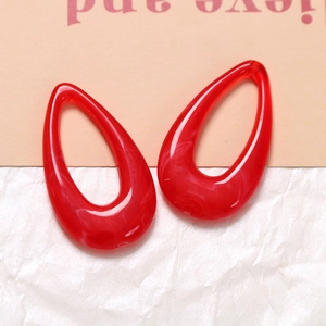 Macro detail of red ink-washed resin teardrop charm with white marble texture