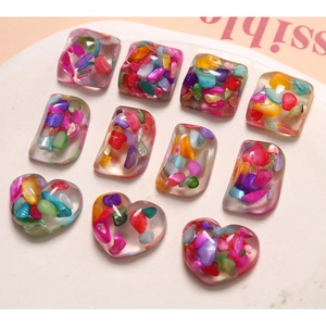 Macro shot of colorful resin heart and square charms with crushed stone inclusions