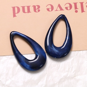 Macro detail of teardrop hollow resin charm with deep blue marble ink texture