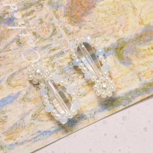 Detail of elegant pearl and blue crystal hair clips on a vintage art background