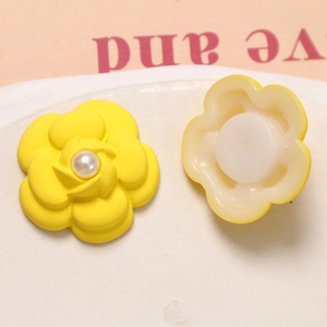Detail of yellow camellia charms with pearl center for DIY crafts and shoe decoration