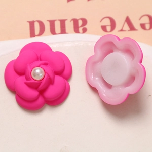 Macro detail of rose red camellia flower charm with pearl center and back buckle base