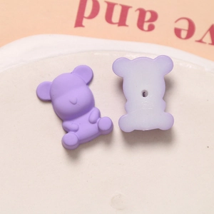 Detail van de voor- en achterkant van een lavendel matte beer bedeltje met boorgat erin