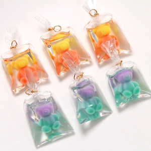 Detail of mini resin bear charms in liquid bags with golden clips and gradient colors