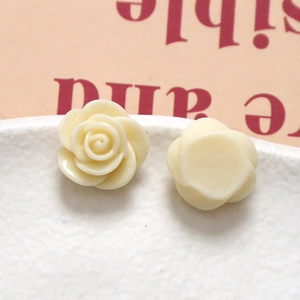 Detailaufnahme von cremefarbenen Rosenblüten aus Harz für DIY-Ohrringe auf Keramik