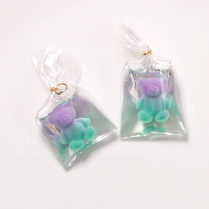 Detail of cute gradient bear pendant in water-filled bag with golden metal ring