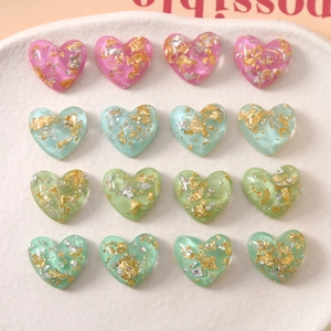 Macro-opname van hartvormige harsbedeltjes met goudfolie voor DIY-sieraden maken