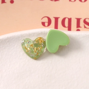 Macro-opname van hartvormige harsbedeltjes met goudfolie en matgroene afwerking