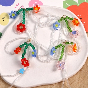 Collier artisanal en perles avec fleurs en acrylique coloré et détails de feuilles vertes