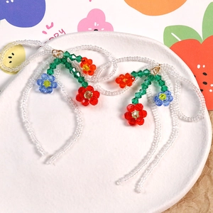 Gros plan de boucles d'oreilles fleuries faites main avec pompons en cristal coloré