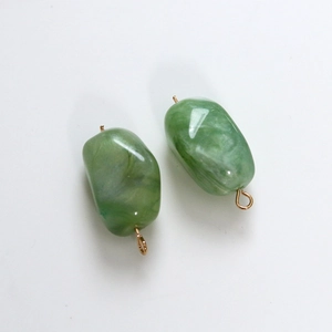 Macro view of olive green resin pebble pendants with marble texture and gold loops